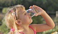 Billede af et barn der drikker et glas vand